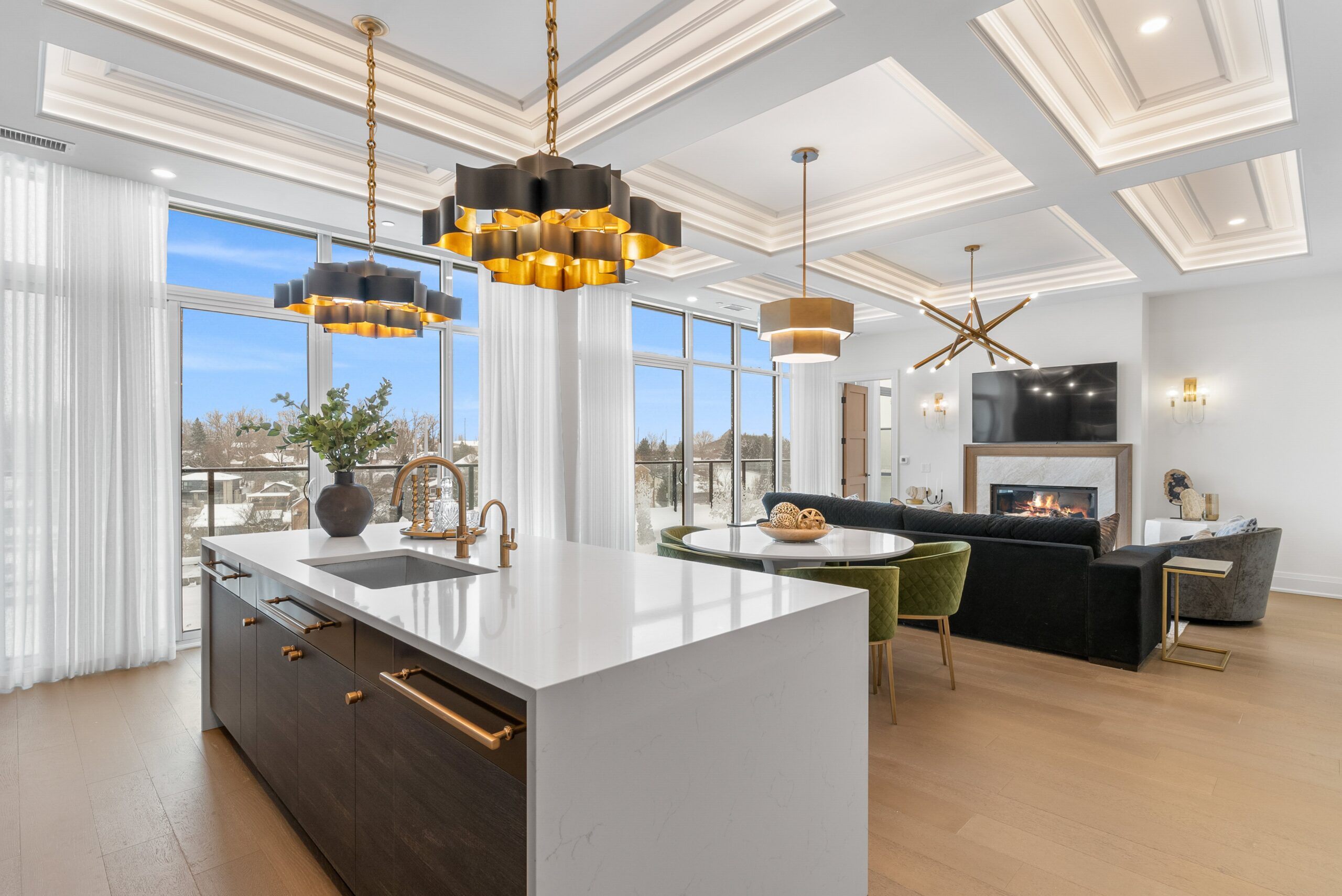 Modern condo kitchen with gold pendants and winter view at Elora Mill