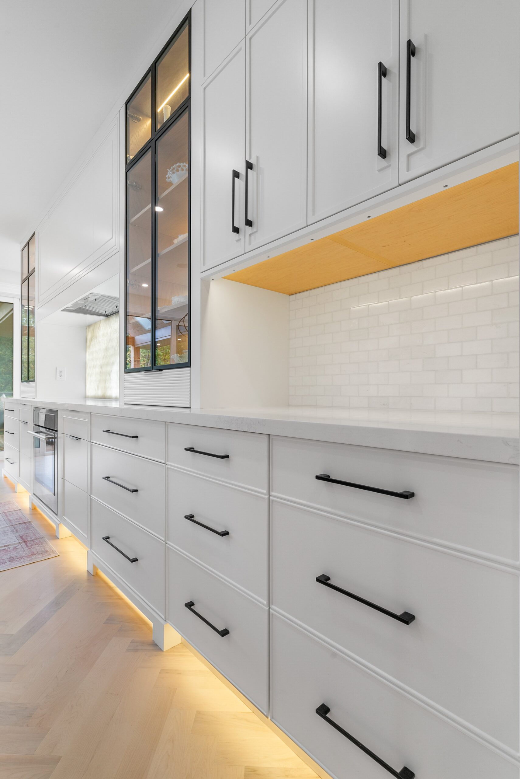 Custom white cabinetry with under-cabinet lighting and matte black hardware