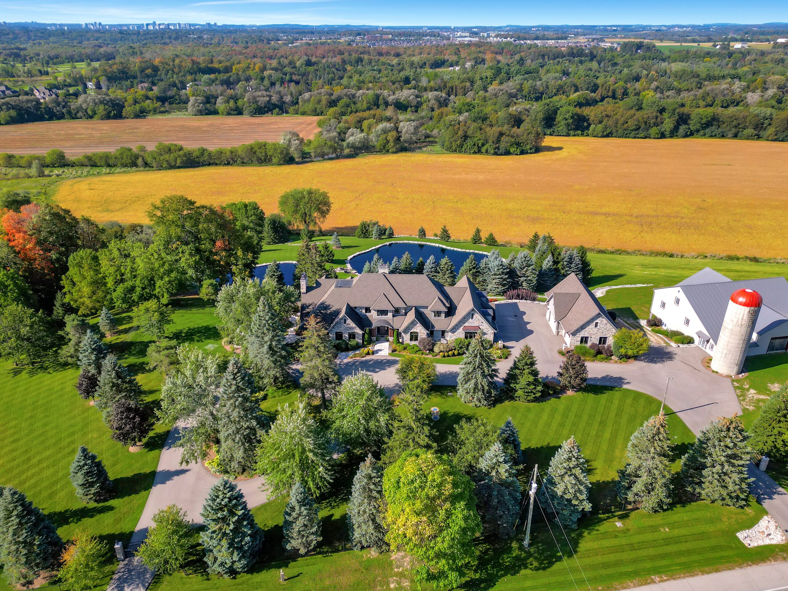 Swimming pond with stone landscaping and farmland view at Waterloo estate
